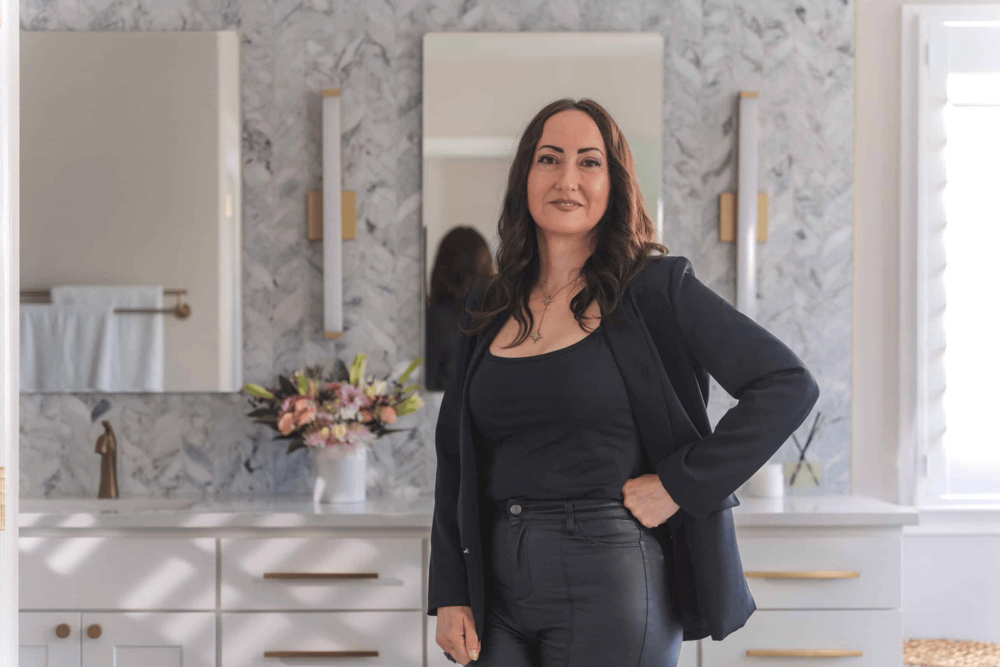a bathroom with a woman standing in front of a mirror